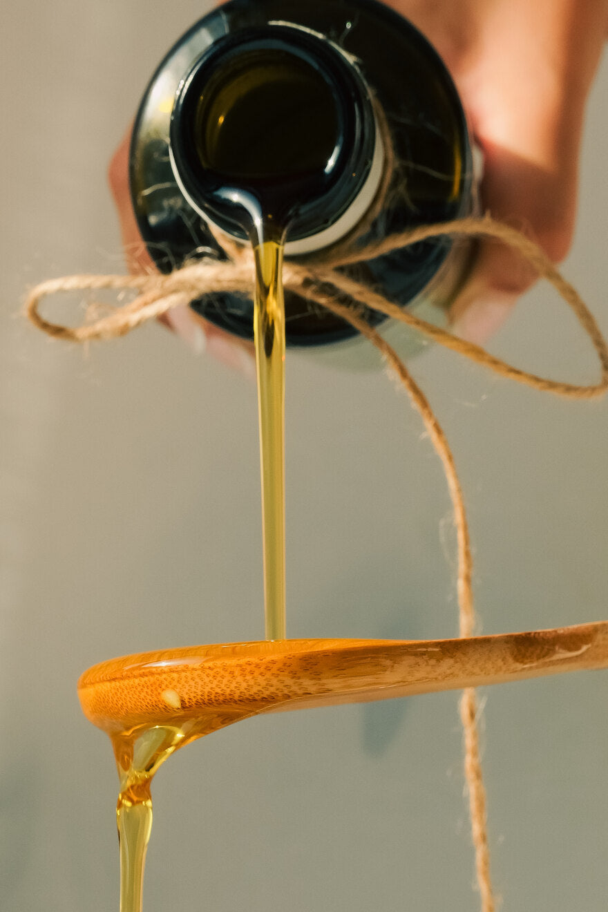 A tasting spoon of green olive oil